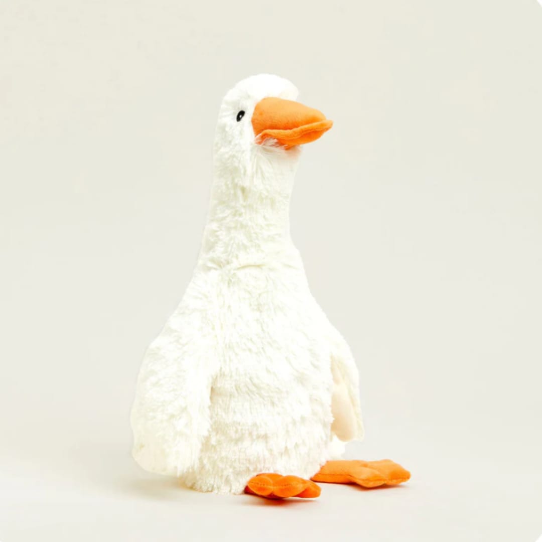White plush duck with an orange beak and feet on a plain background