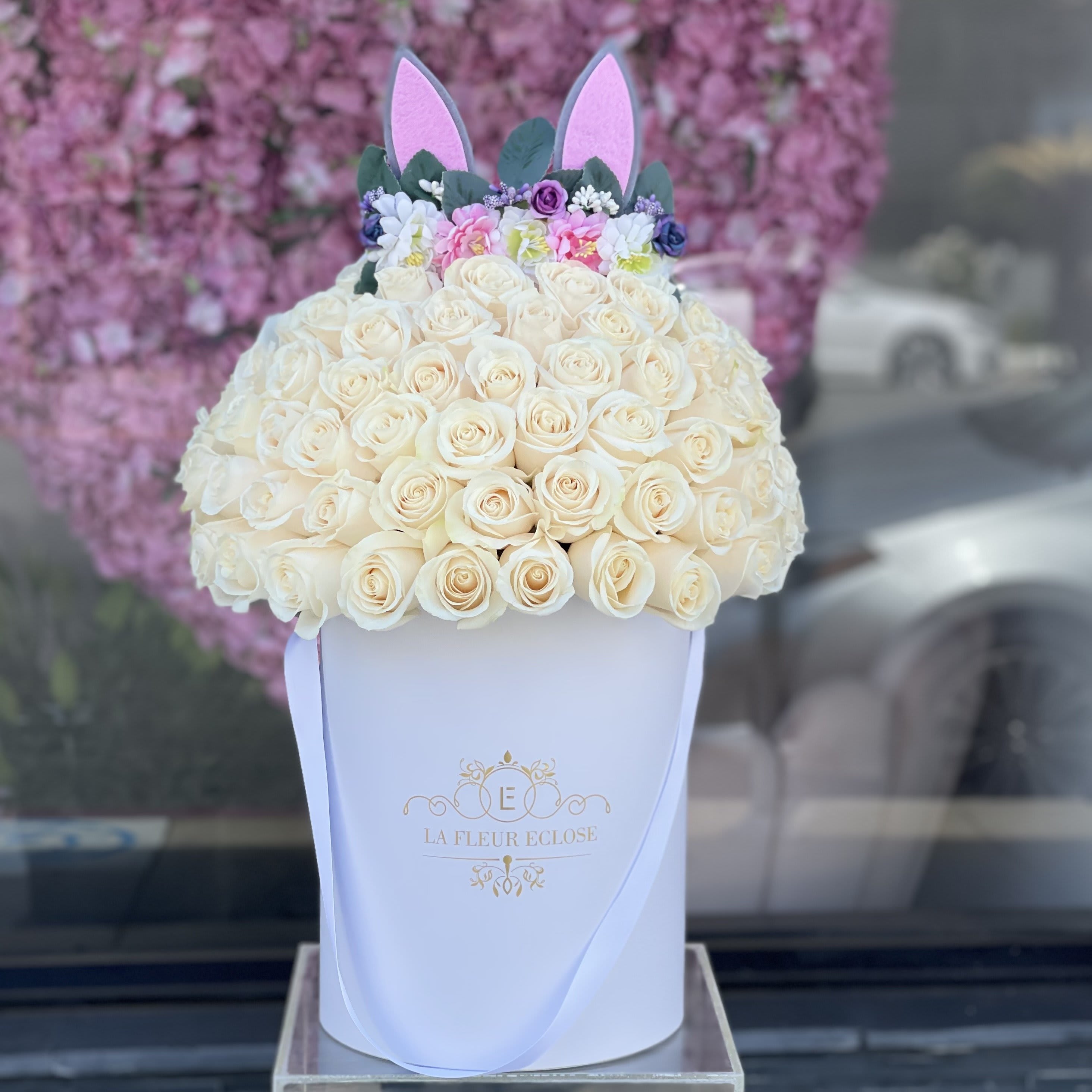 Cream rose arrangement in a white hat box with pink bunny ears
