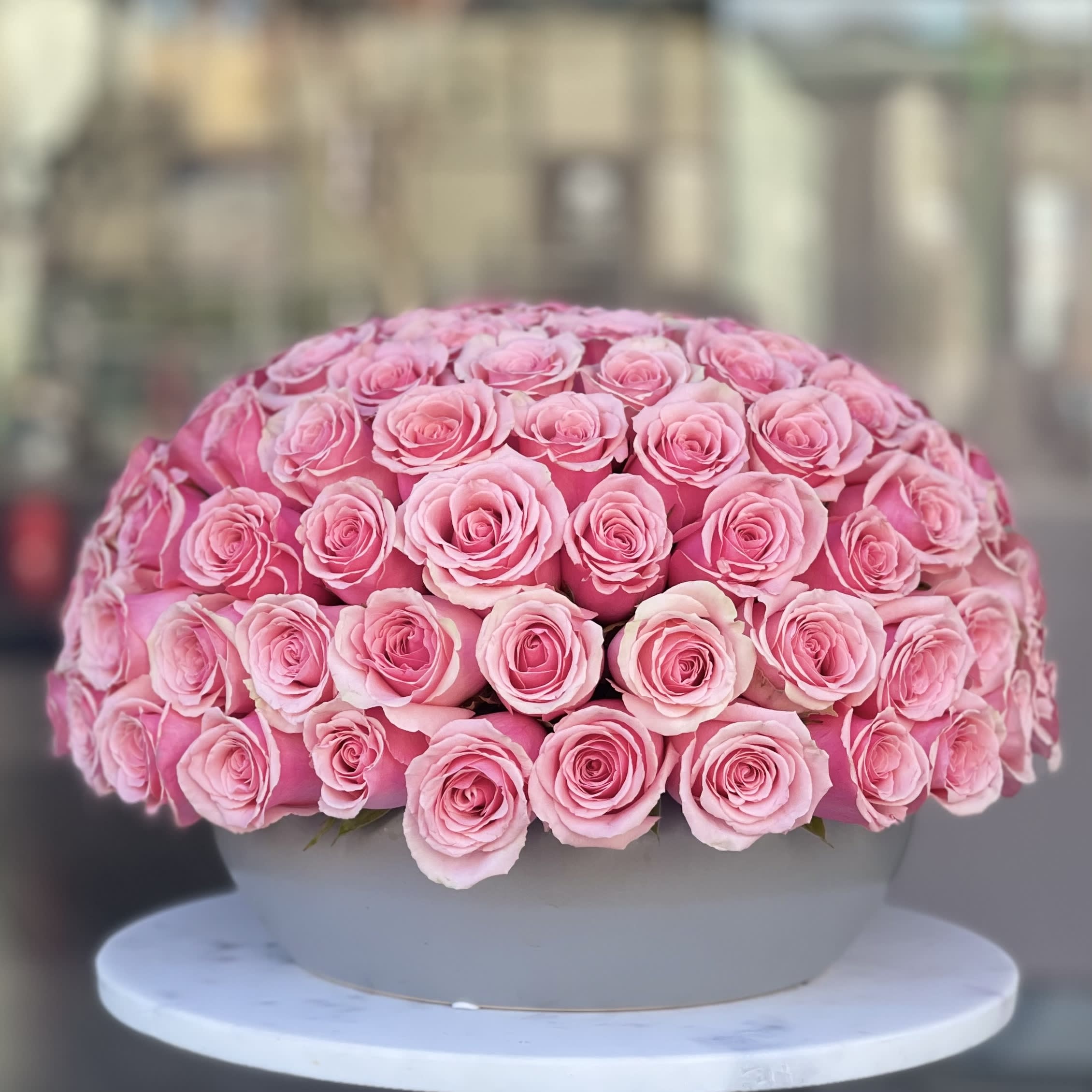 Large dome arrangement of pink roses in a round box