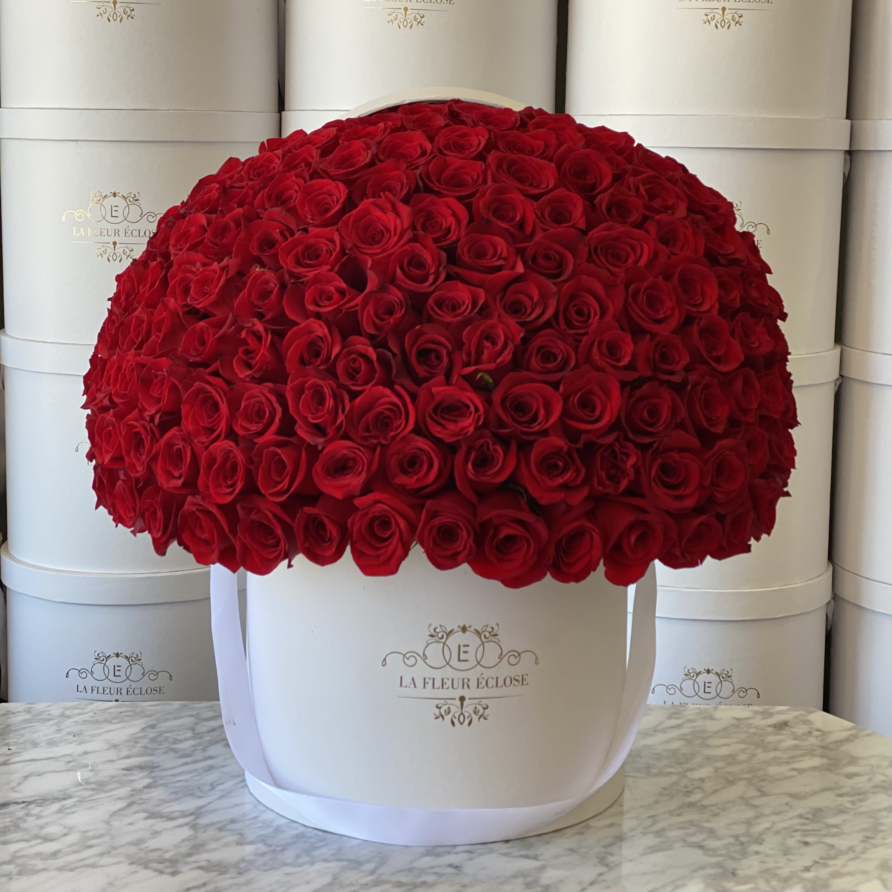 Large dome of red roses in a white hatbox