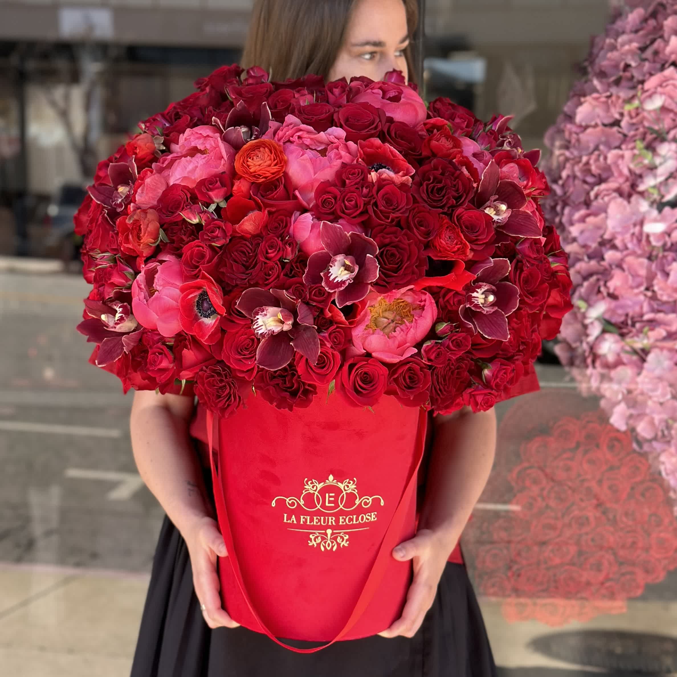 Red Velvet Delight  - The flower arrangement features an elegant display of premium red flowers beautifully arranged in a luxurious red velvet box. The rich red hues of the flowers complement the opulence of the velvet box, creating a striking and sophisticated look. This arrangement exudes a sense of luxury and romance, making it a perfect gift for special occasions or to add a touch of glamour to any space. The combination of premium red flowers and a red velvet box creates a stunning visual impact that is sure to impress and delight the recipient.