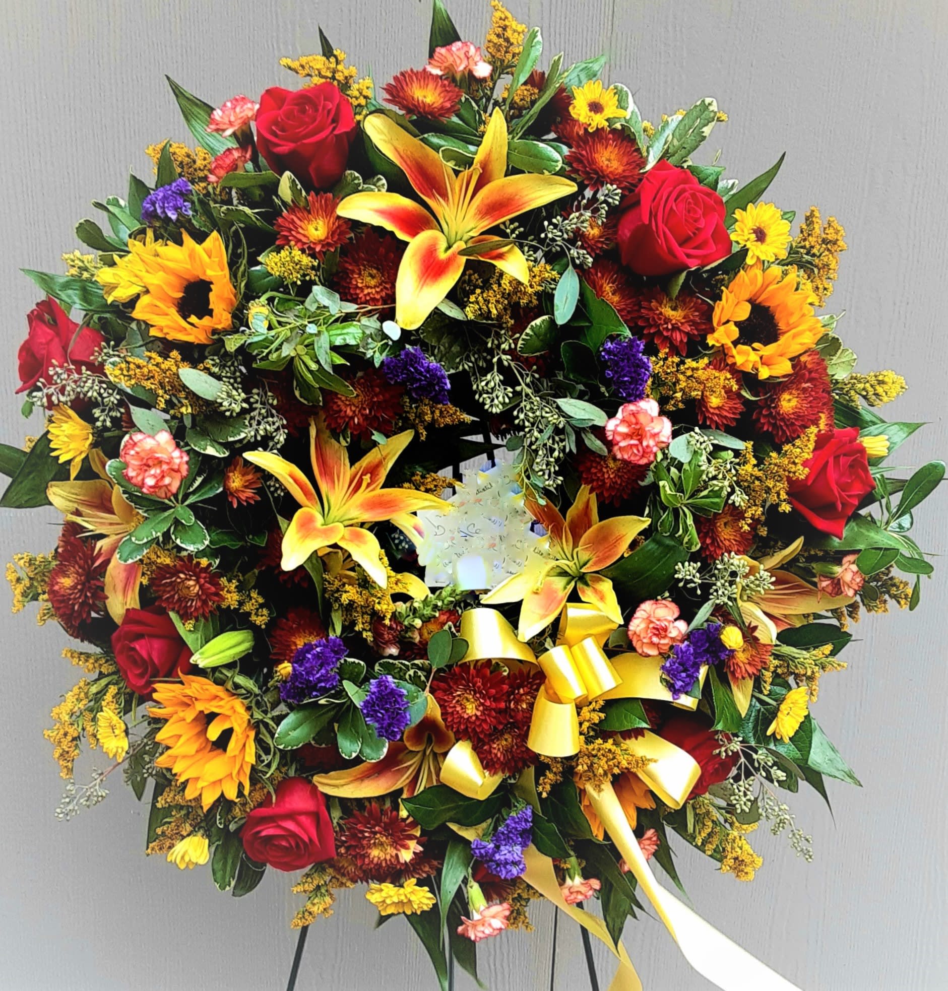 Bright Sympathy Wreath - Full of memories of fall flowers, roses and lilies. Approximately 36" across.