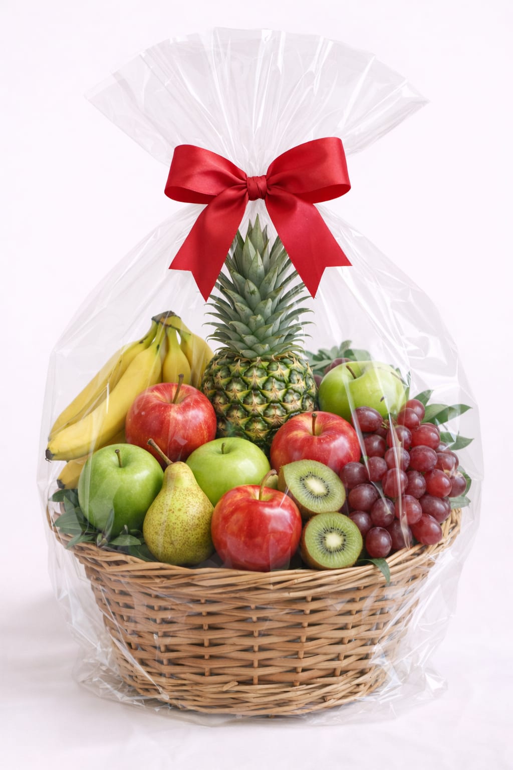 Fruit basket with bananas, apples, grapes, pineapple, pear, and kiwi wrapped in cellophane