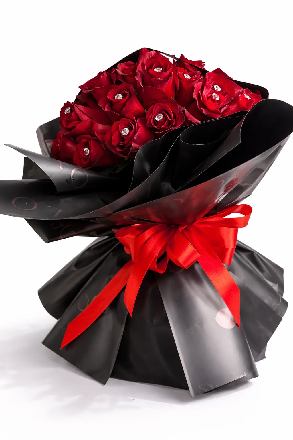 Bouquet of red roses wrapped in black paper with a red ribbon