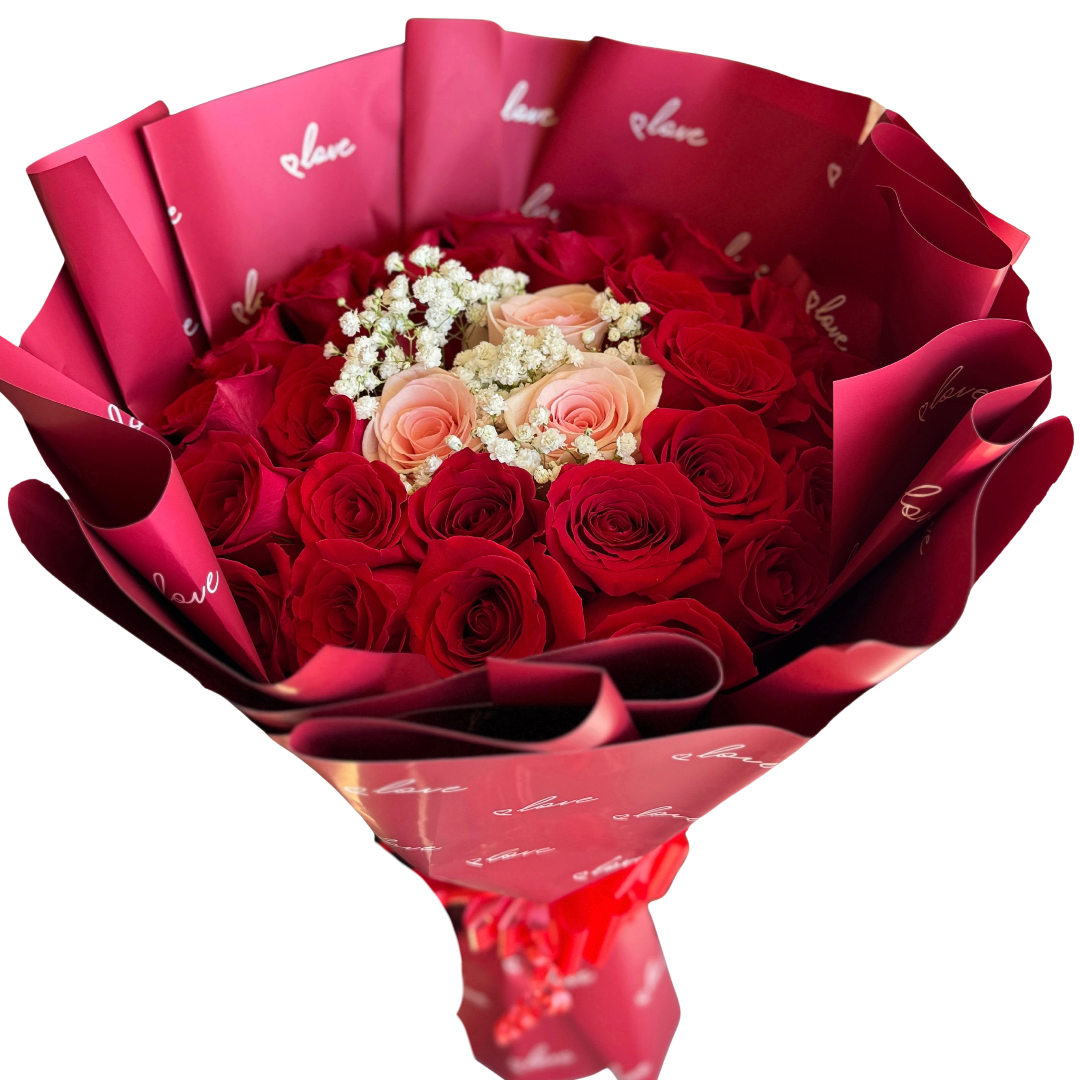 Bouquet of red and blush roses wrapped in pink paper
