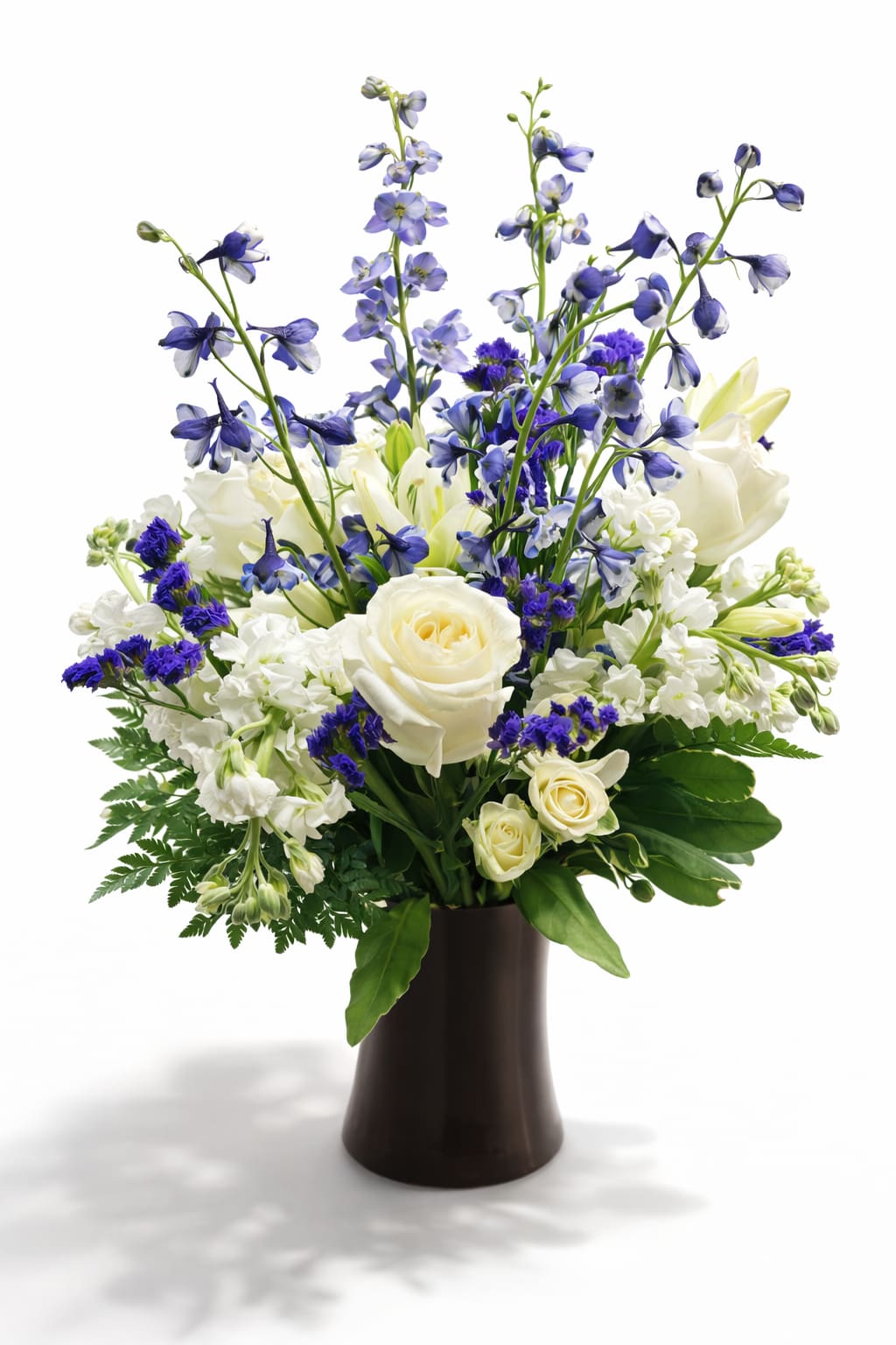 White and blue floral arrangement in a dark vase
