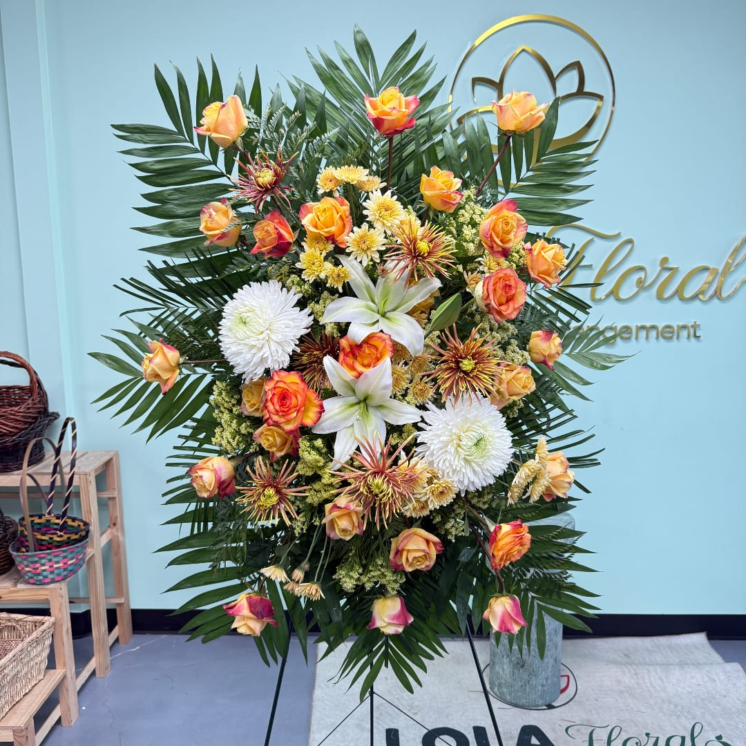 Large floral standing spray with roses, lilies, and white chrysanthemums