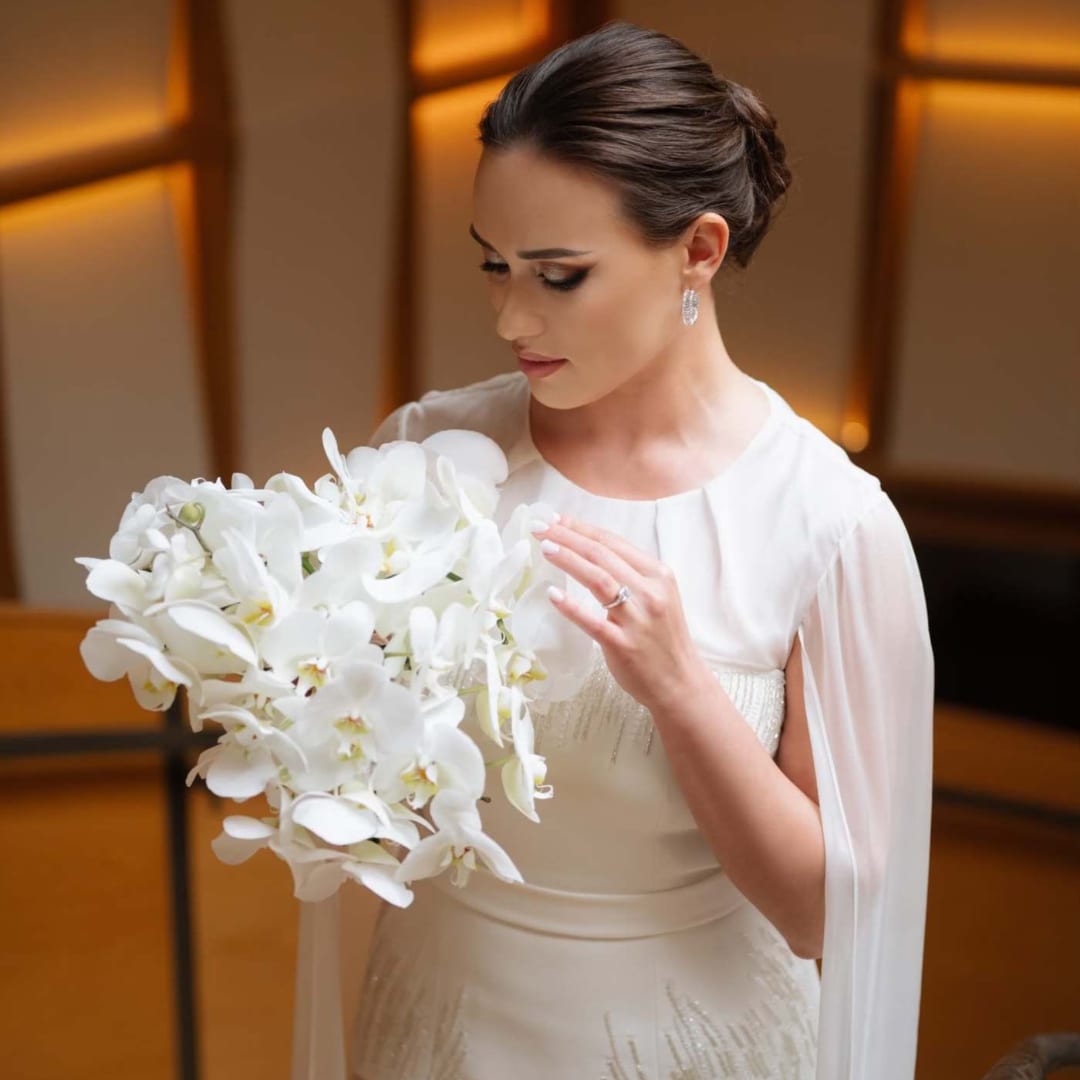 Bride holding a large white orchid bouquet