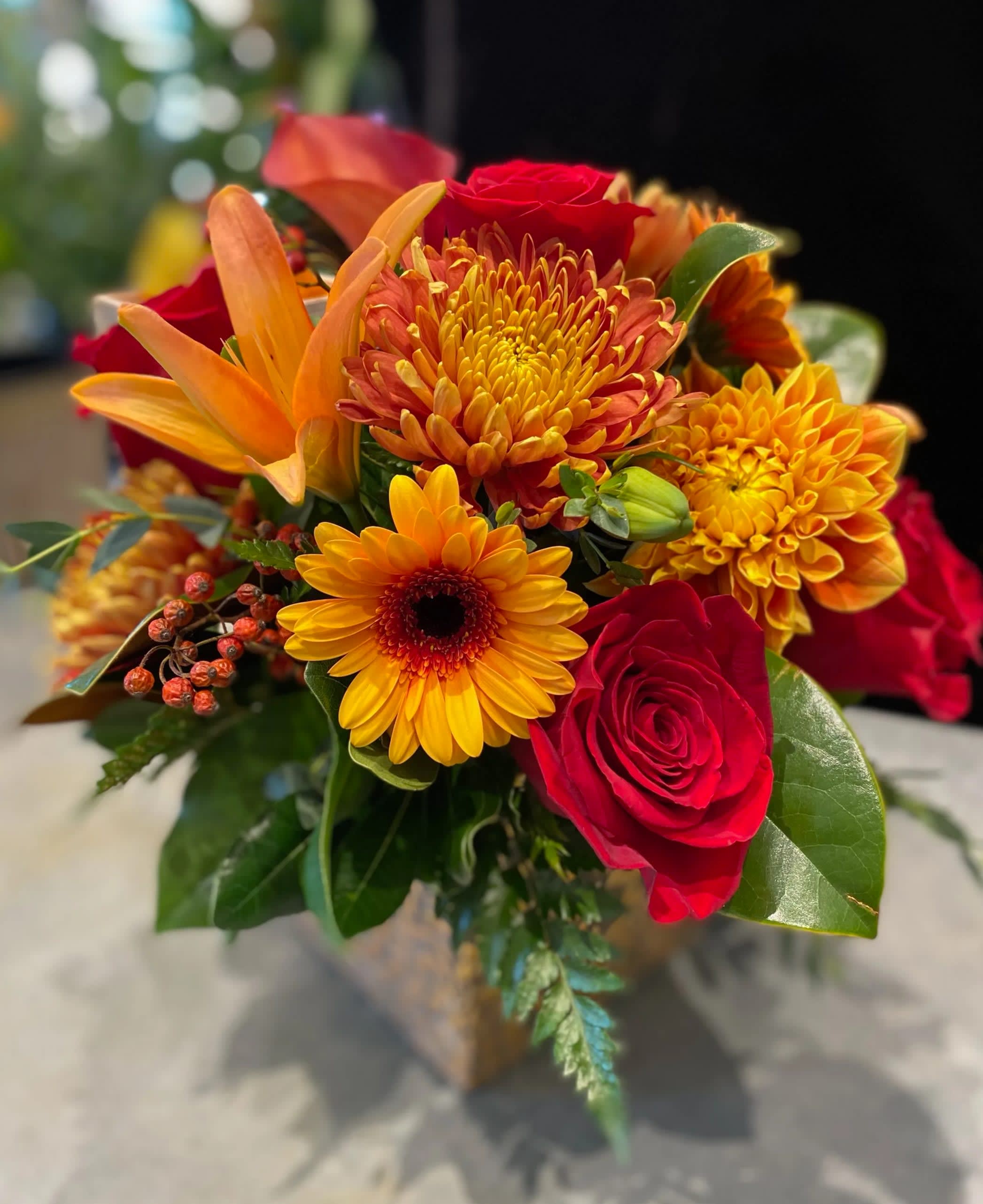 Bouquet of red roses, orange lilies, and yellow chrysanthemums