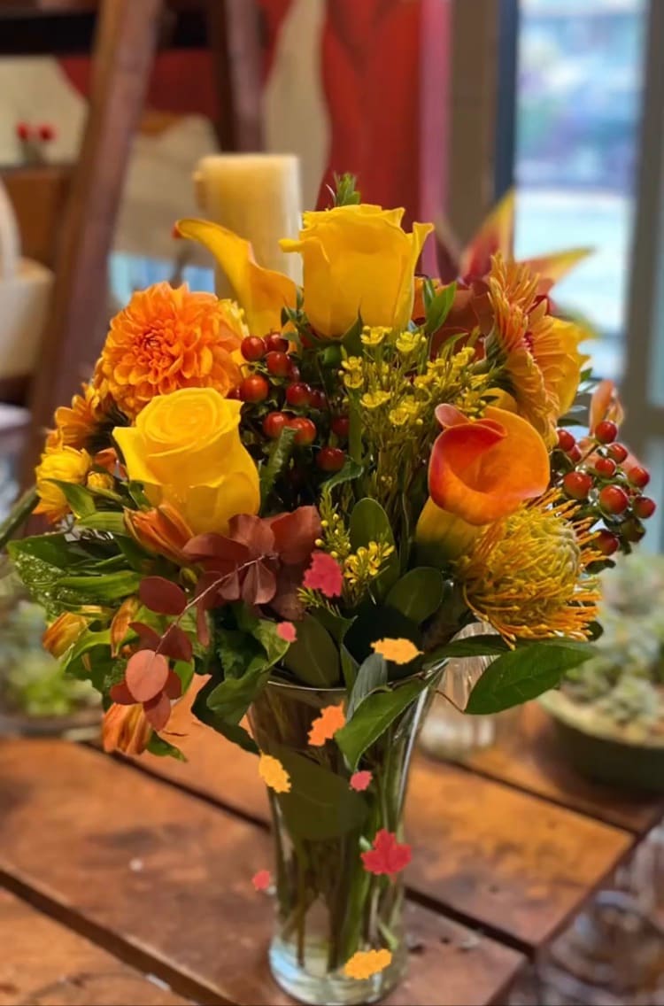 Yellow and orange floral arrangement in a clear glass vase