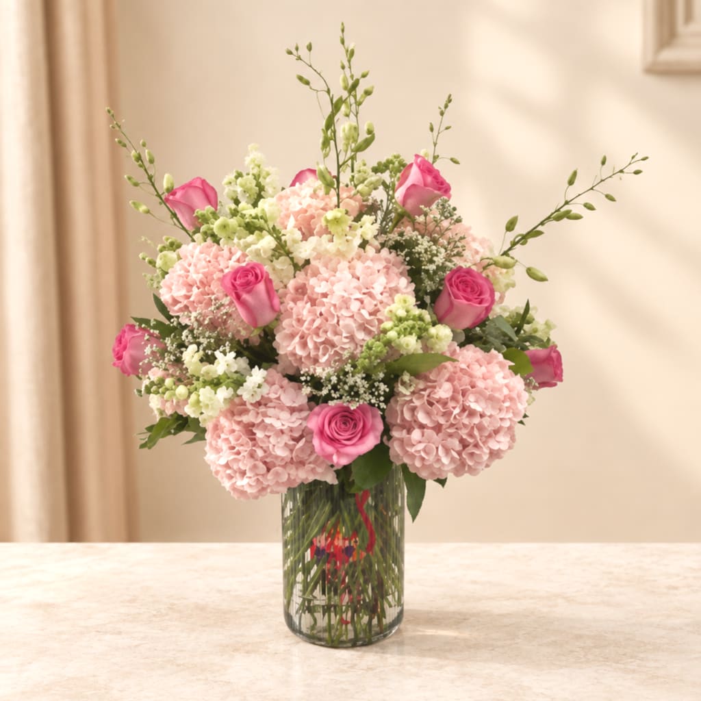 Pink hydrangea and rose bouquet in a clear glass vase