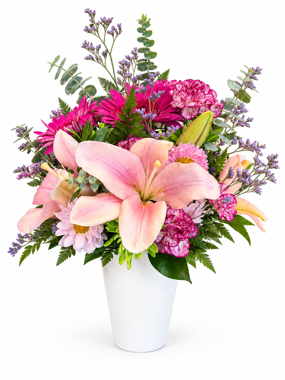 Pink lilies and mixed blooms arranged in a white vase