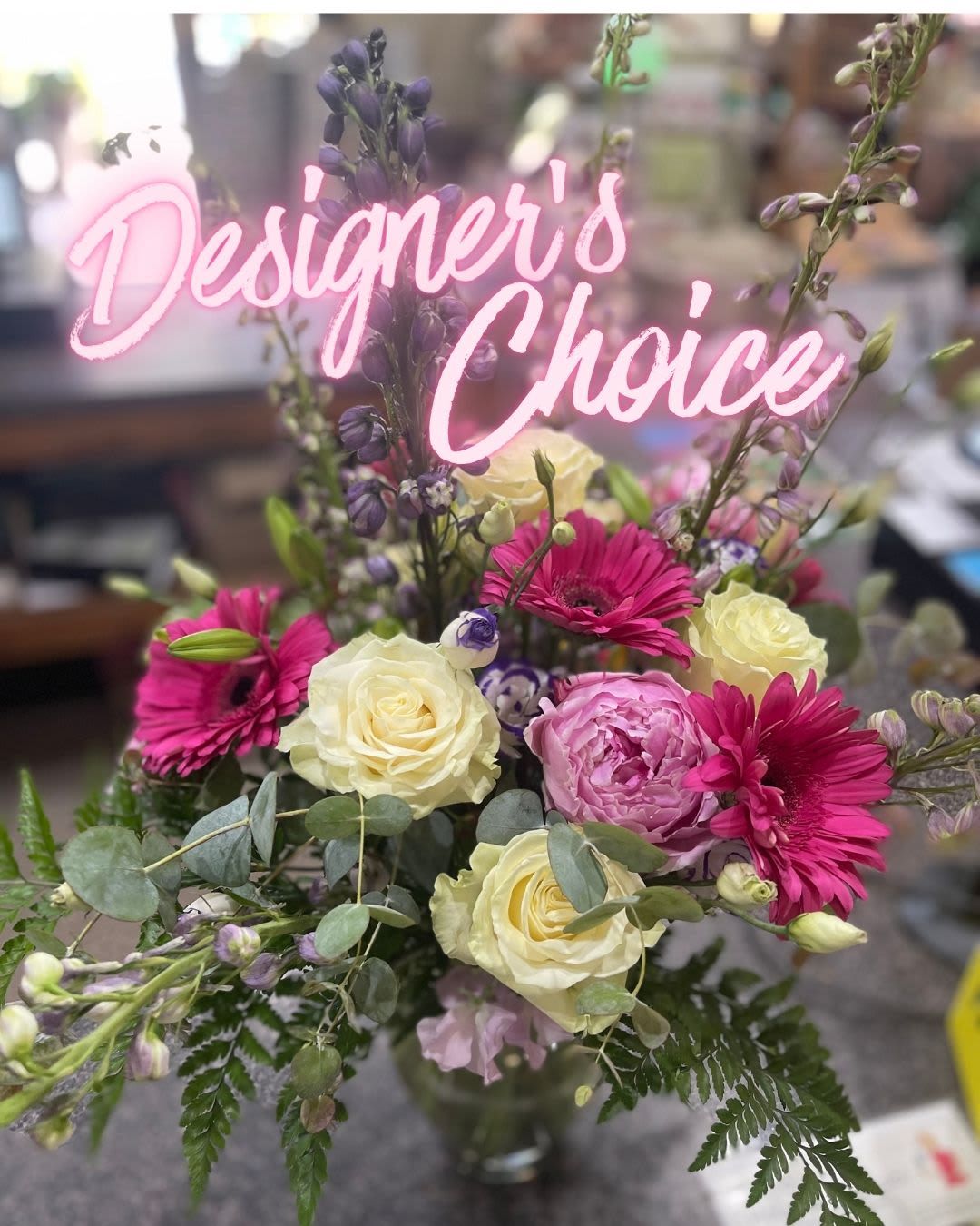 Mixed bouquet with pink gerbera daisies and cream roses in a glass vase
