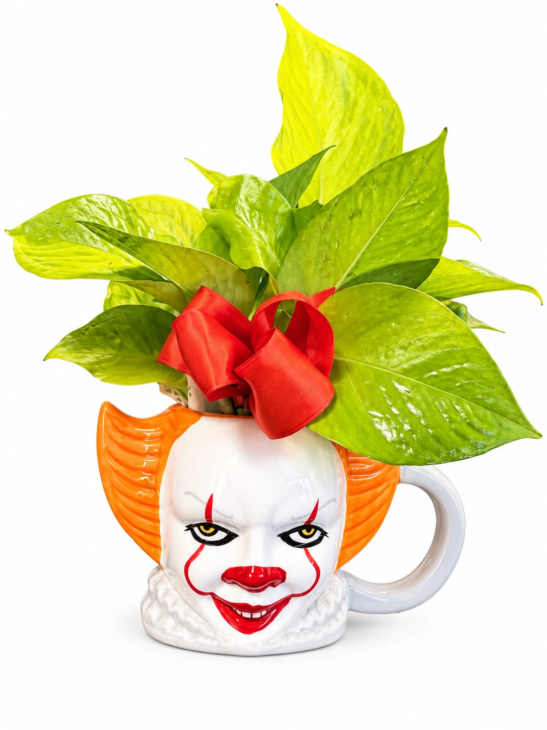 Potted green plant in a clown-face mug with a red ribbon