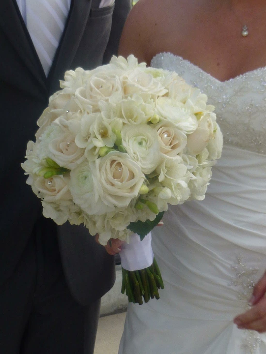 Bride holding a white bouquet of roses and ranunculus
