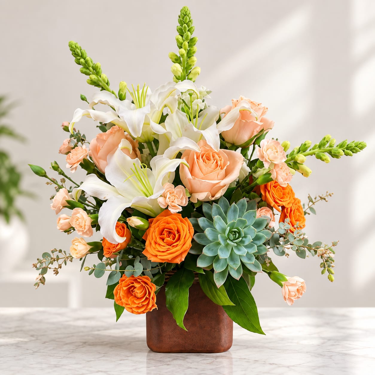 Peach roses and white lilies in a brown vase with a succulent accent