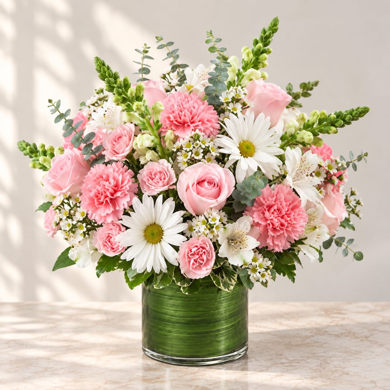 Pink and white mixed bouquet in a green glass vase