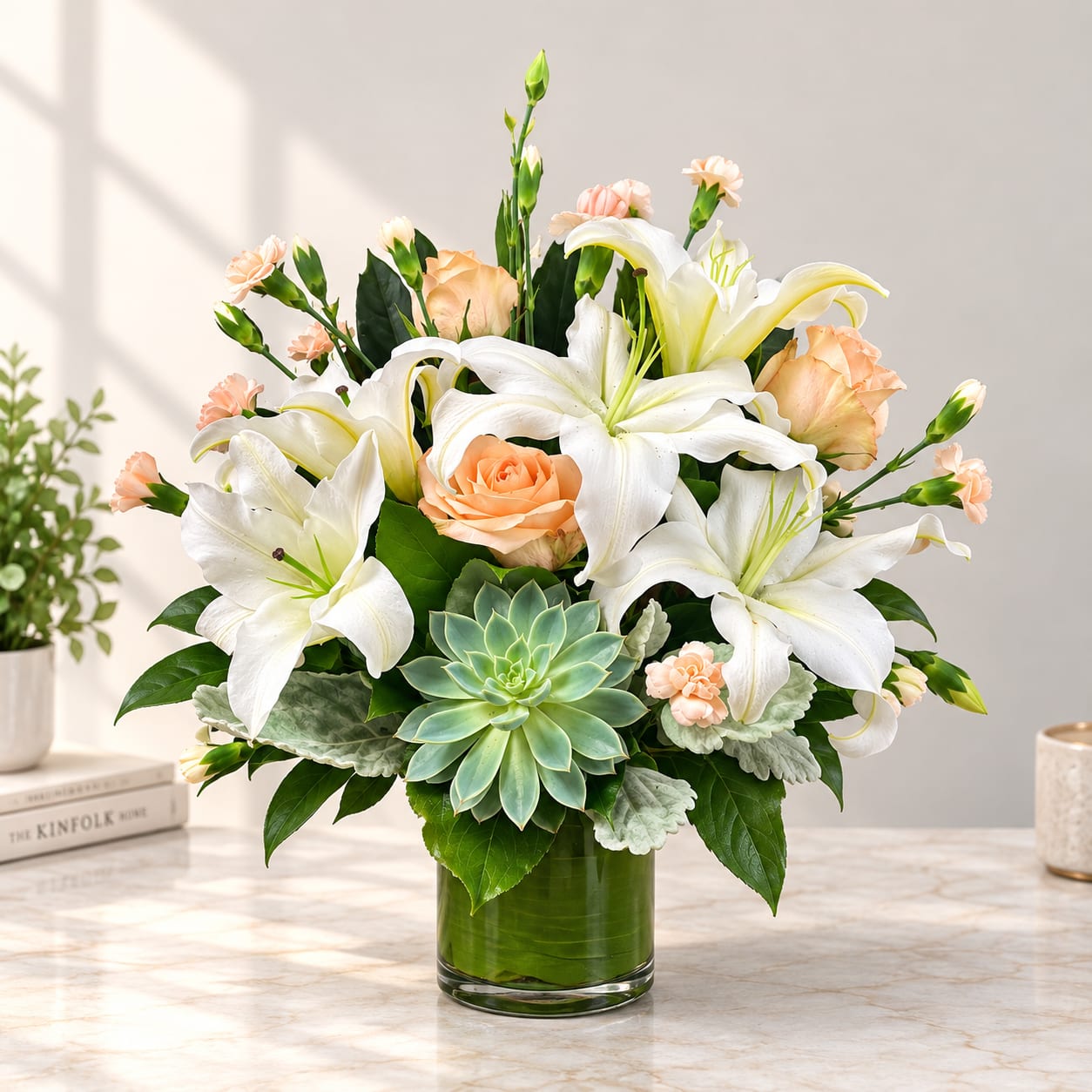 White lilies and peach roses in a glass vase with a succulent accent