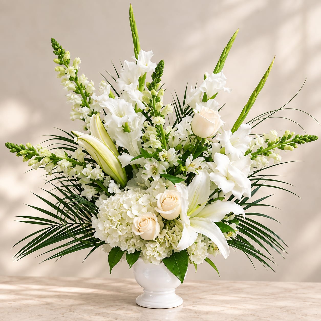 White floral arrangement in a white vase with lilies and roses