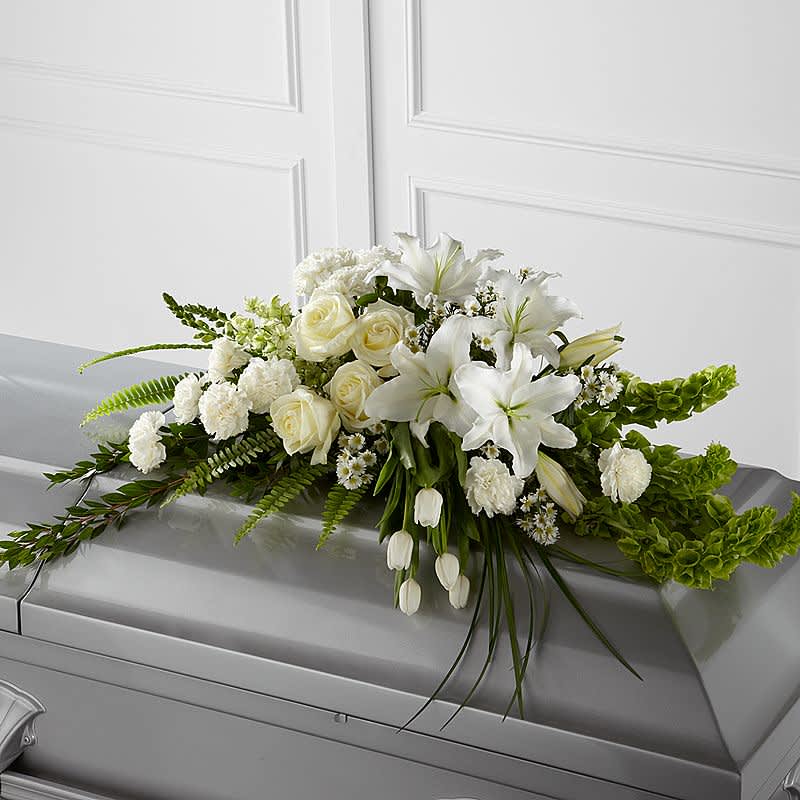 White floral casket spray with roses and lilies