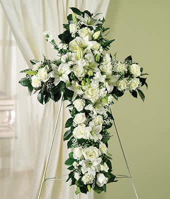 White floral cross arrangement on a stand