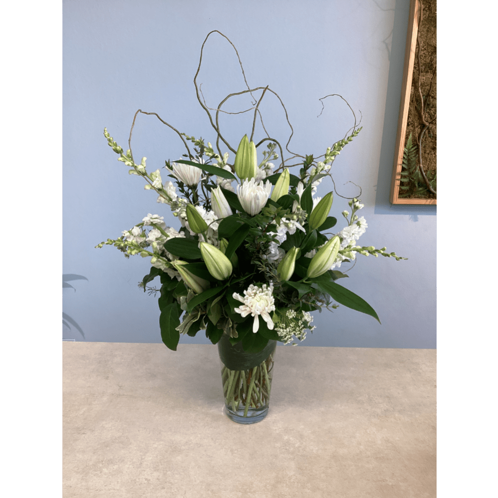 White lilies and chrysanthemums in a clear glass vase