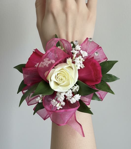 Hot Pink Corsage - This corsage features two hot pink and one white spray rose, with baby's breath, greenery. If you would like all roses to be hot pink or a different color please write it on the customer notes at checkout or give us a call.