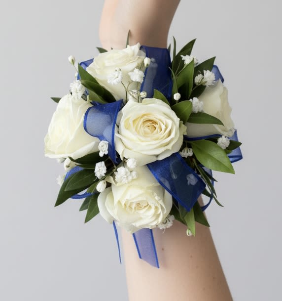 White Rose Corsage with Royal Blue Ribbon - White rose corsage accented with greenery, baby’s breath, and a royal blue ribbon. For a different ribbon color, add a note at checkout.