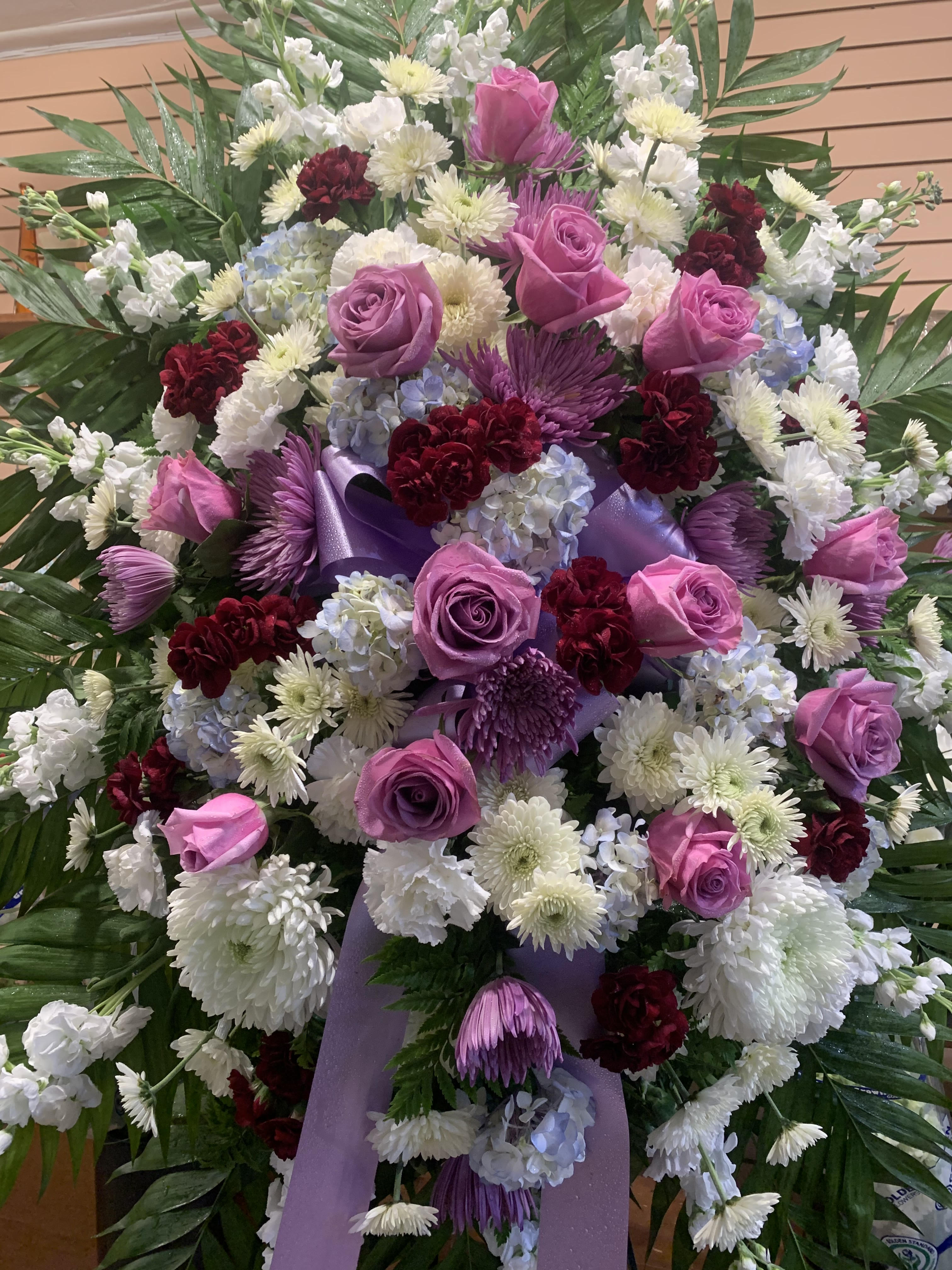 Large standing spray of pink roses, white chrysanthemums, and purple ribbon