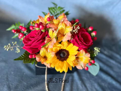 WARMNESS - Embrace the radiant spirit of Warmness in a purse! Our captivating flower arrangement that marries the vibrant energy of sunflowers, the timeless elegance of roses, and the warmth of orange blooms. Each petal in this ensemble tells a story of sunshine and joy, creating an arrangement that radiates positivity. Let "Warmness" bring a burst of color and cheer into your space, a celebration of nature's brilliance and the uplifting power of floral artistry.