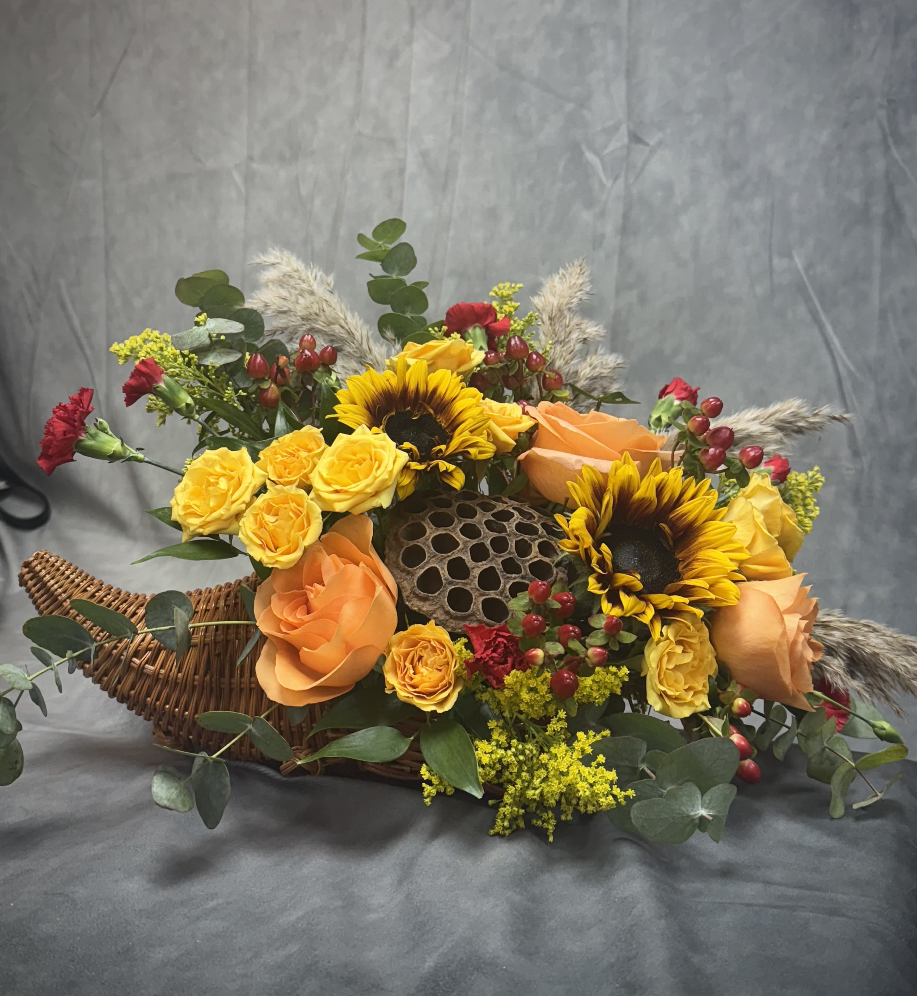 Harvest Cornucopia - Introducing our Harvest Cornucopia a stunning arrangement featuring vibrant sunflowers and unique dried lotus and pampas grass, celebrating the season’s natural beauty. This beautiful display brings together warmth, texture, and autumn charm in one perfect centerpiece. 