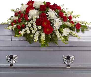Red and white floral spray on a silver casket