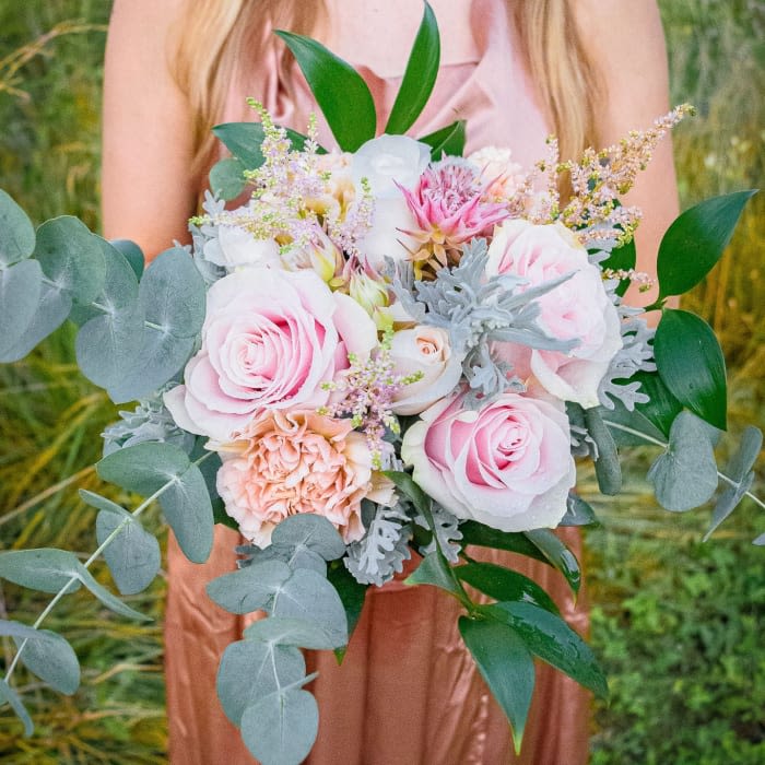 Bride holding a pastel bouquet of pink and white roses with eucalyptus