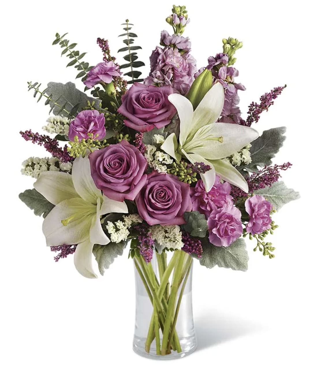 Purple roses and white lilies in a clear glass vase