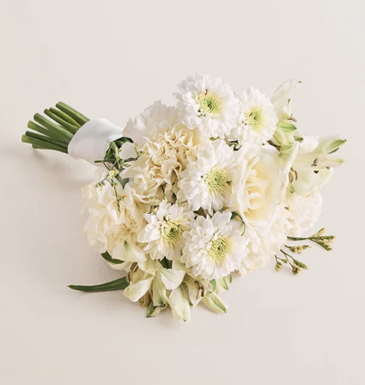 White bouquet with daisies, roses, and lilies tied with a white wrap