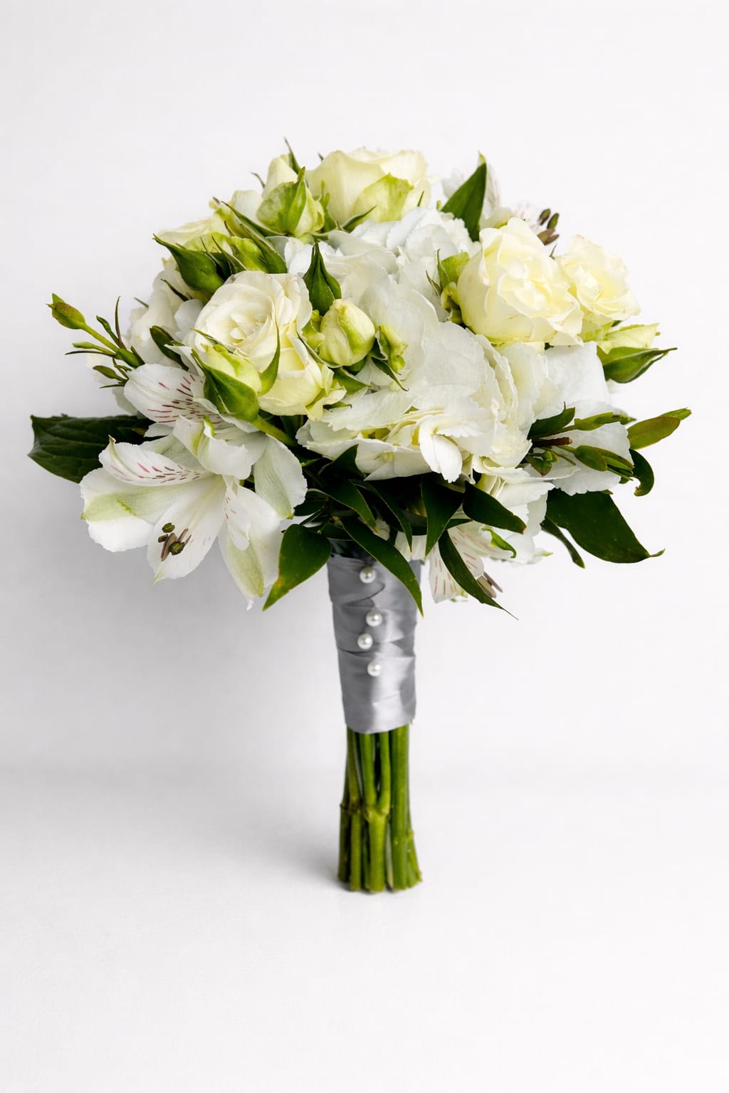 White bouquet with roses and lilies wrapped in silver ribbon