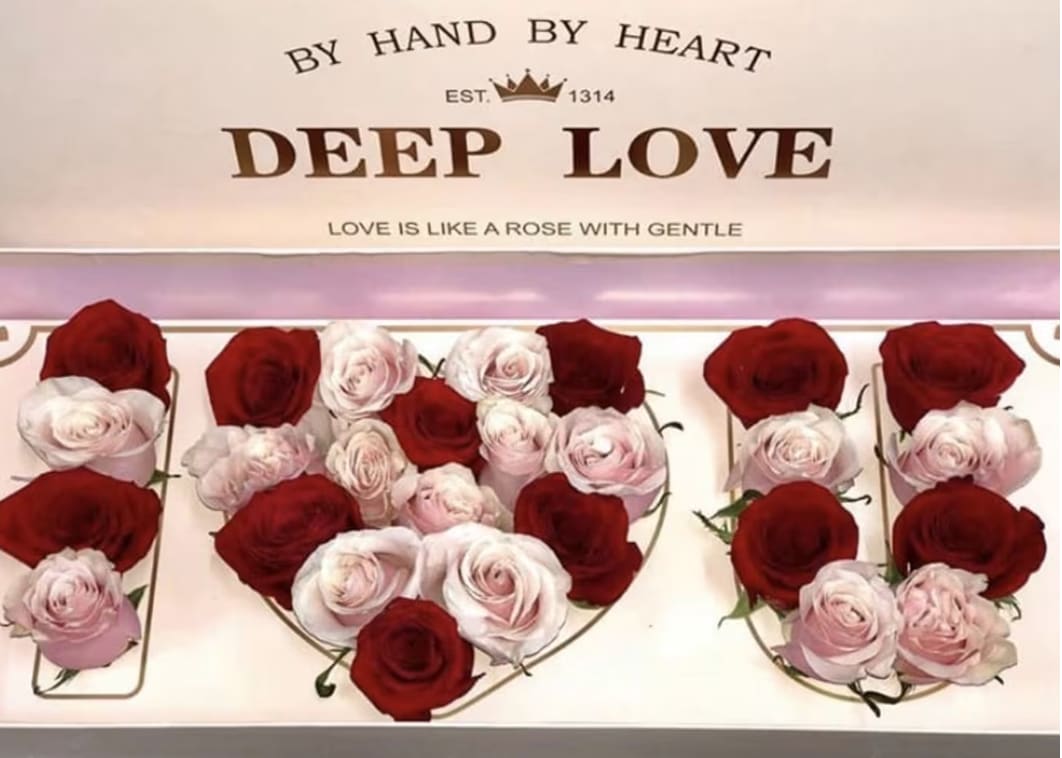 Heart-shaped rose arrangements in red and pale pink with a gift box
