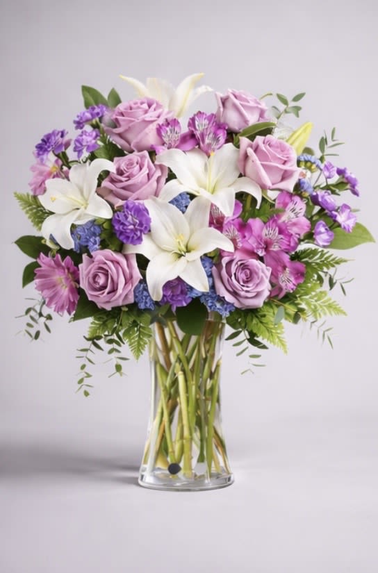 Bouquet of lavender roses and white lilies in a clear glass vase