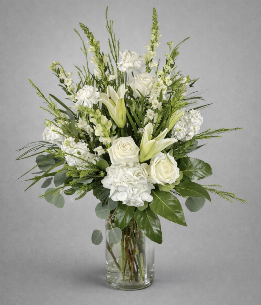 White roses and lilies in a clear glass vase