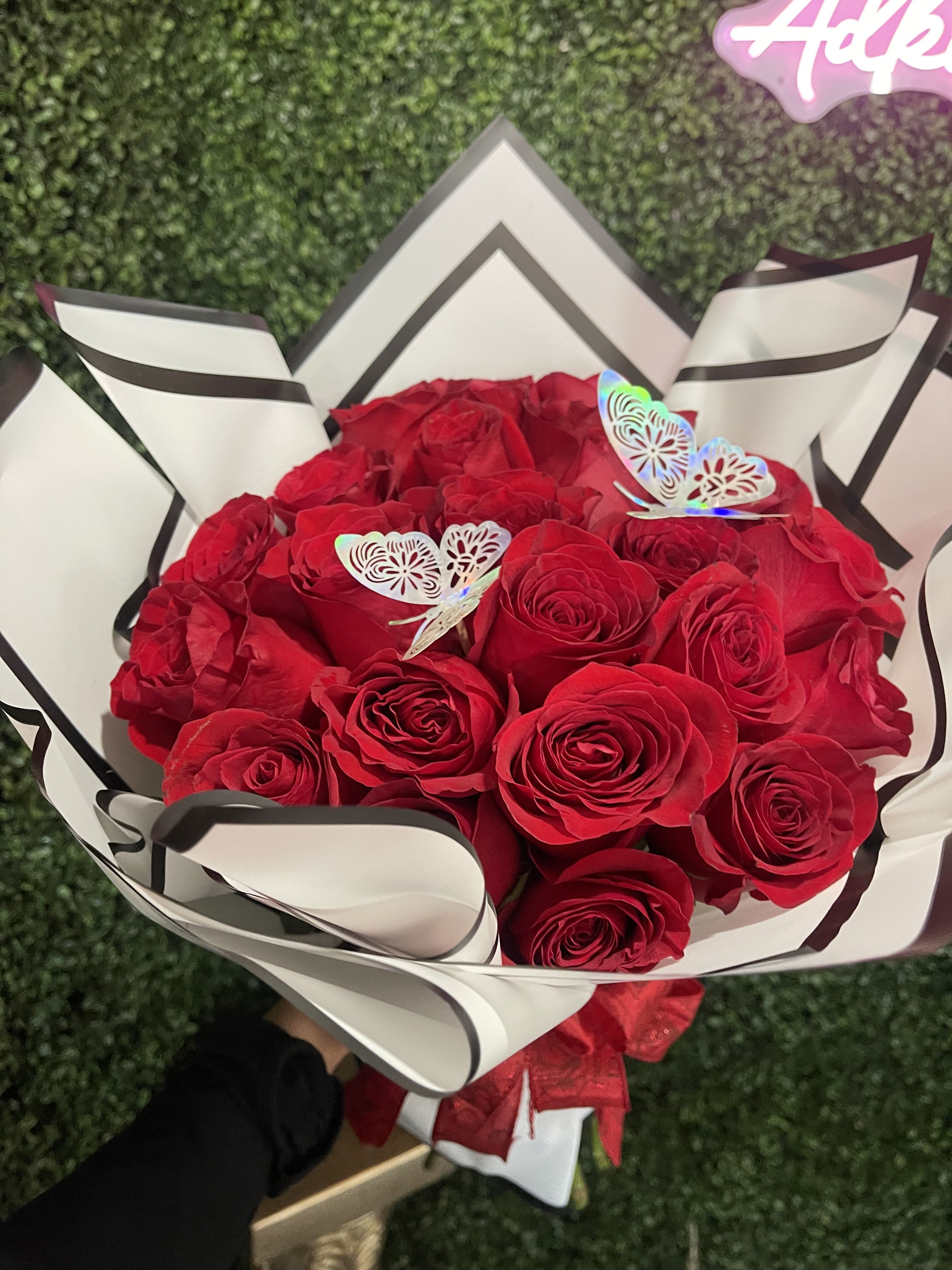 Bouquet of red roses wrapped in white paper with black trim
