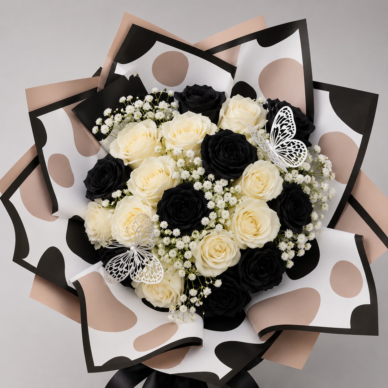 Bouquet of black and cream roses with baby’s breath and butterfly accents