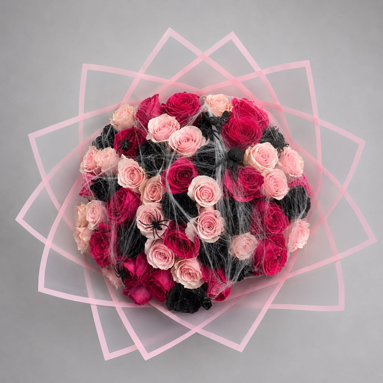 Round bouquet of pink and black roses with pink geometric wrap