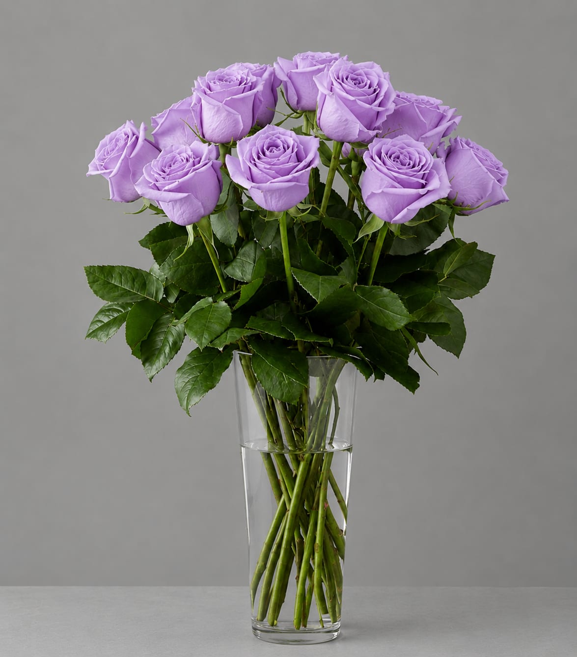 Lavender roses arranged in a clear glass vase