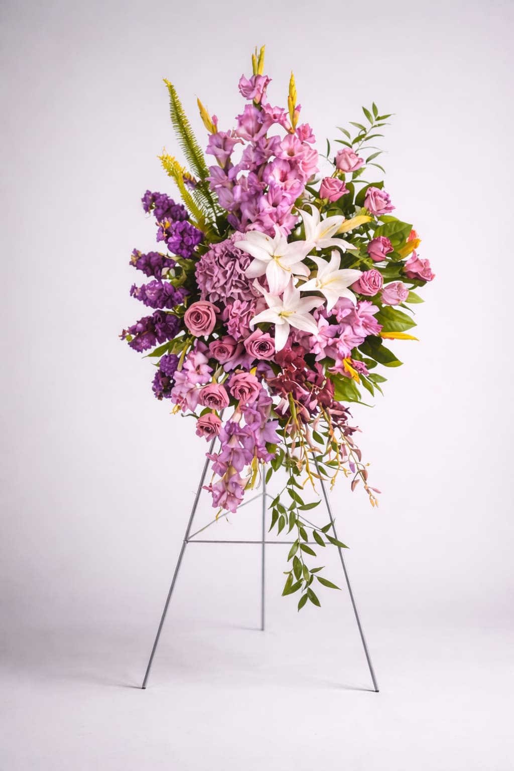 Tall floral spray with pink, purple, and white blooms on a metal stand