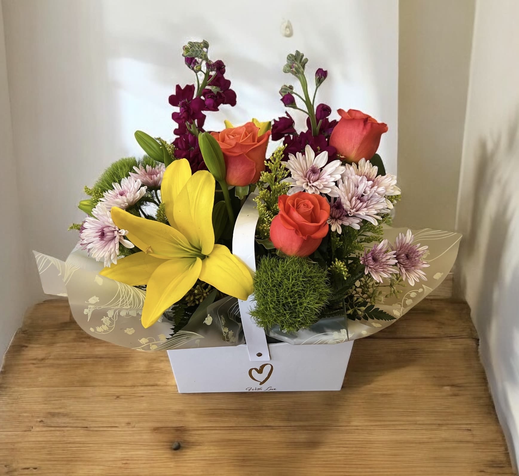 Mixed bouquet with roses, lilies, and daisies in a white gift box