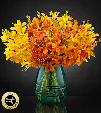 Autumn Skies Bouquet - Create that perfect splash of color inspired from the stunning view of a desert sunset across the bluest sky. A mix of gold and orange mokara orchids have a look of gleaming confetti accented with pincushion protea to give it a southwestern chic look. Set in an aqua swirled glass vase that flaunts a modern design aesthetic to create even further appeal, this bouquet was put together by our team of esteemed floral artisans to help you send the absolute best in floral design.   Note: Because this vase has been discontinued, we will have to substitute another vase for this picture vase.