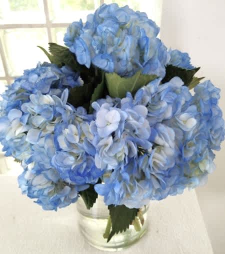 Blue hydrangea bouquet in a clear glass vase