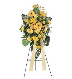 Yellow floral standing spray on an easel with ribbon