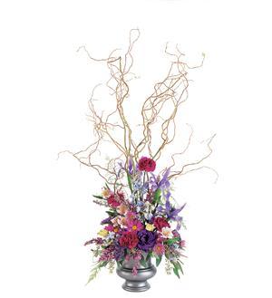 Tall floral arrangement with colorful blooms in a silver vase