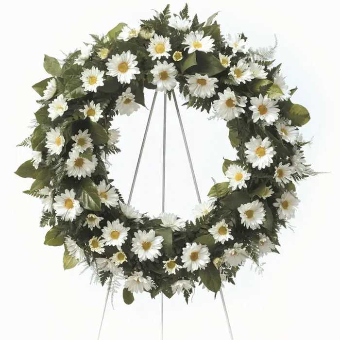 White daisy funeral wreath on a metal stand